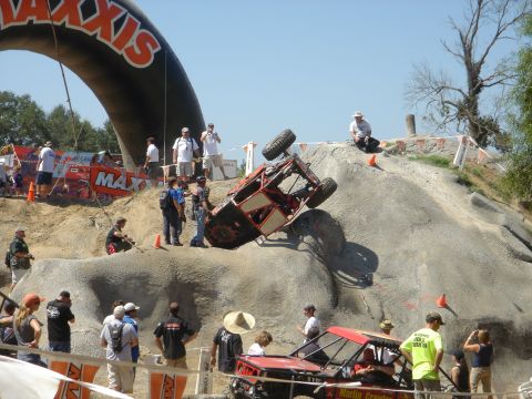 2002 Jeep Wrangler - An off-road competition features a vehicle struggling on a challenging course with onlookers observing the action.