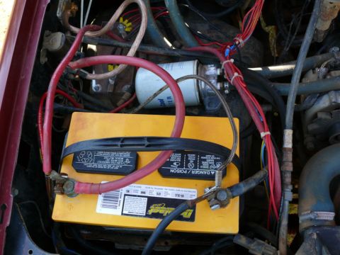 1988 Ford Bronco - The engine bay shows a battery, wiring, and a fuel filter. The year is not discernible from this view.