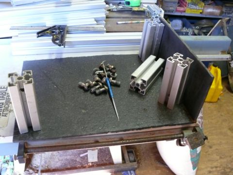1988 Ford Bronco - Aluminum extrusions and hardware are laid out on a workbench, possibly for a project.