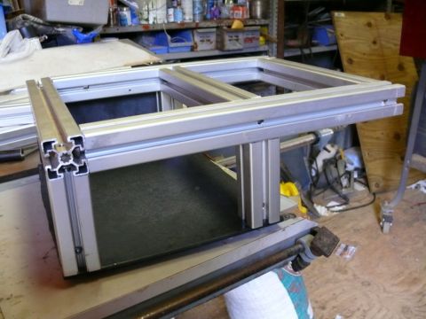 1988 Ford Bronco - Aluminum extrusion frame assembly sits on a workbench in a workshop setting.