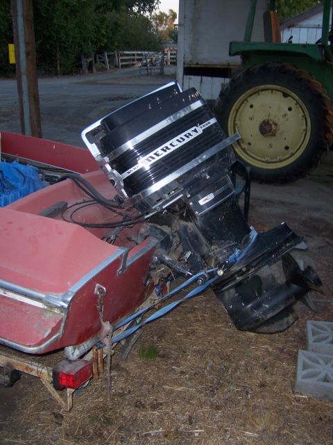 1991 Ford Bronco - Mercury outboard motor mounted on the transom of a red boat.