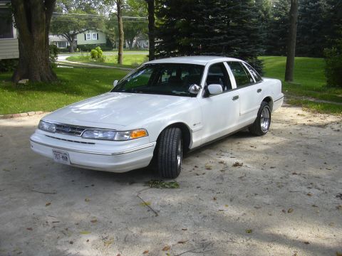 1997 Ford Crown Victoria - This white 1997 Ford Crown Victoria sedan is parked on a driveway in front of a residential home.