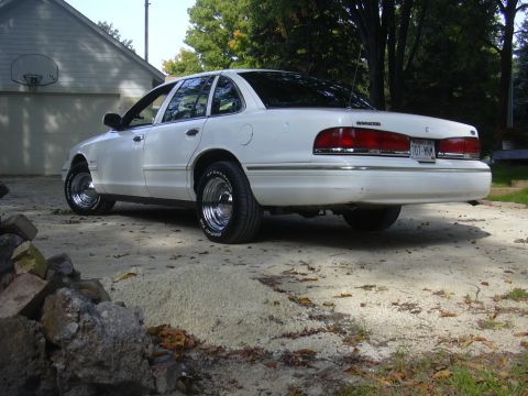 1997 Ford Crown Victoria - Rear view of a white 1997 Ford Crown Victoria sedan with chrome wheels.