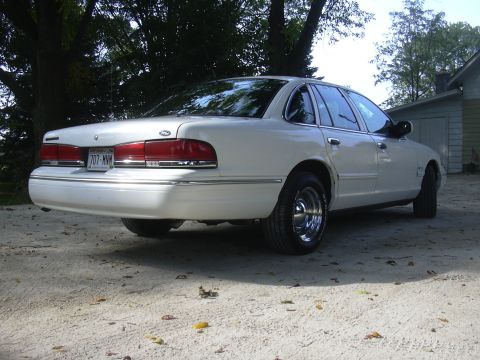 1997 Ford Crown Victoria - Rear 3/4 view of a white 1997 Ford Crown Victoria sedan with chrome wheels.