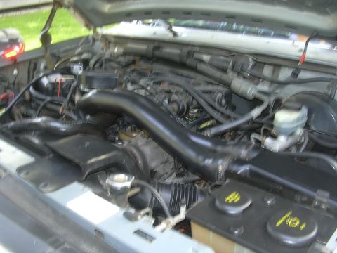 1997 Ford Crown Victoria - The engine bay of a vehicle is visible, a prominent black intake tube and a Supermotors.net logo in the lower right corner.