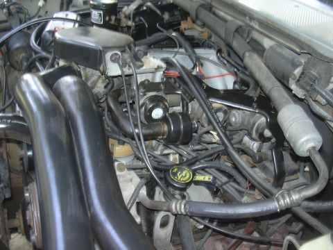 1997 Ford Crown Victoria - Close-up view of a vehicle's engine bay, showing hoses, wires, and mechanical parts.