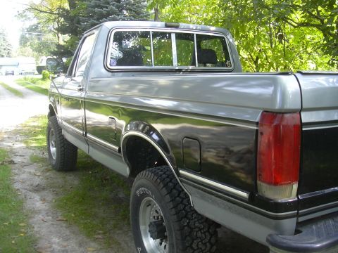 1997 Ford Crown Victoria - This Ford F-Series truck features a two-tone paint scheme with chrome trim and off-road tires.