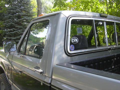 1997 Ford Crown Victoria - A two-tone pickup truck is parked outdoors with trees in the background.