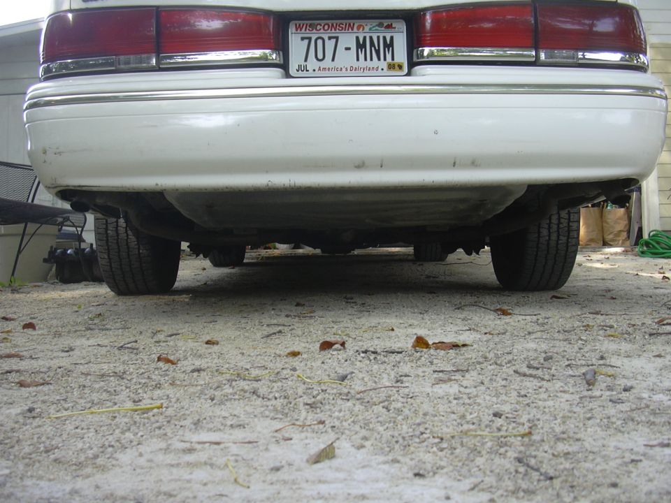 1997 Ford Crown Victoria rear underside, showing exhaust and suspension components. Wisconsin license plate 707-MNM is visible