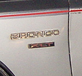 1986 Ford Bronco - Close-up of a Bronco emblem on the side of a vehicle, with a Supermotors.net watermark visible.