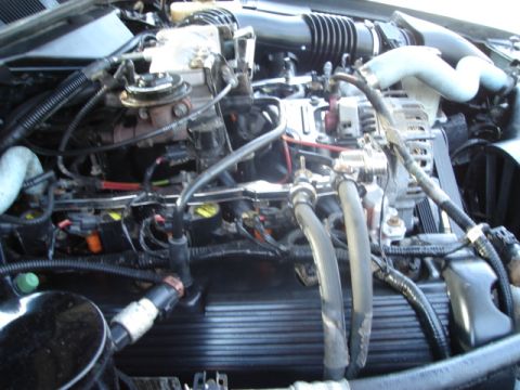 2000 Ford Crown Victoria - Close-up view of an engine bay, showing various hoses, wires, and engine components.