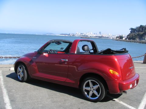 2005 Chrysler PT Cruiser - Red 2005 Chrysler PT Cruiser convertible parked near the water with a city skyline in the distance.