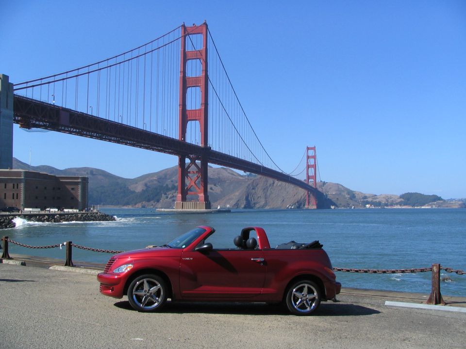 Red convertible PT Cruiser parked with the Golden Gate Bridge in the background