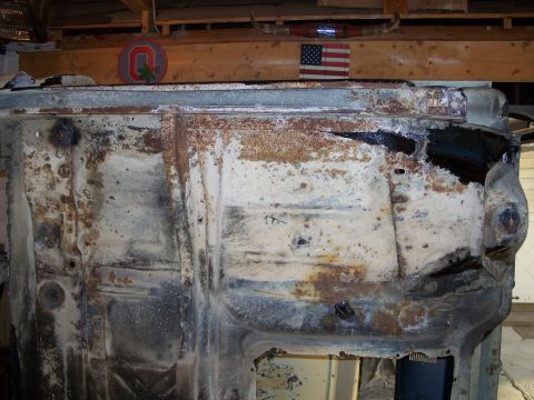 1979 Ford F-150 - The heavily rusted undercarriage of a vehicle is visible, with evidence of past repairs and extensive corrosion.