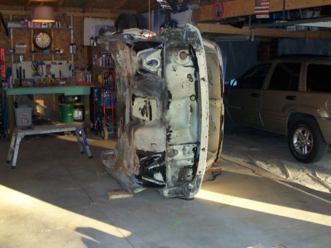 1979 Ford F-150 - The underside of a vehicle chassis is visible, possibly undergoing restoration or repair in a garage setting.