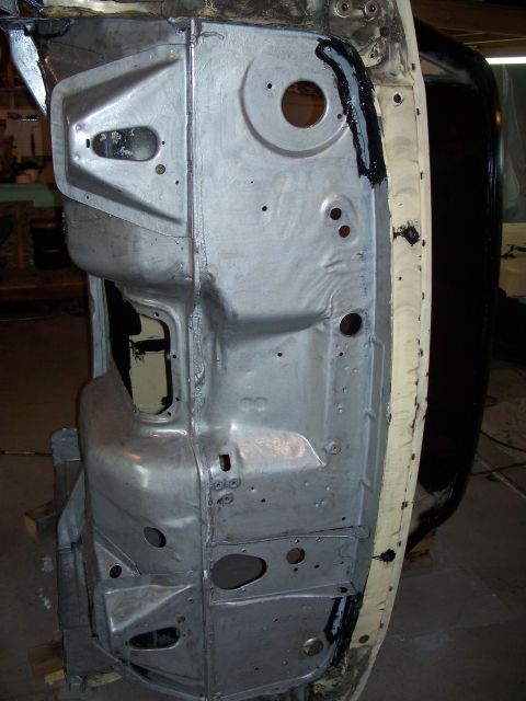 1979 Ford F-150 - Close-up view of a vehicle's bare metal frame section, showing structural details and some sealant application.