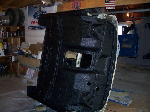 1979 Ford F-150 - The undercarriage of a vehicle is being treated with a protective coating in a workshop setting.
