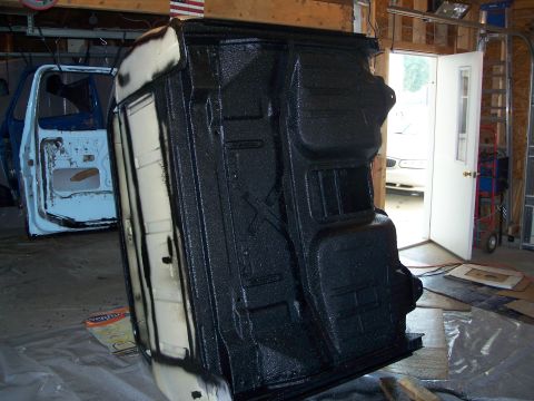 1979 Ford F-150 - The undercarriage of a 1979 Ford F-150 is coated in black, with the truck's cab visible in the background.