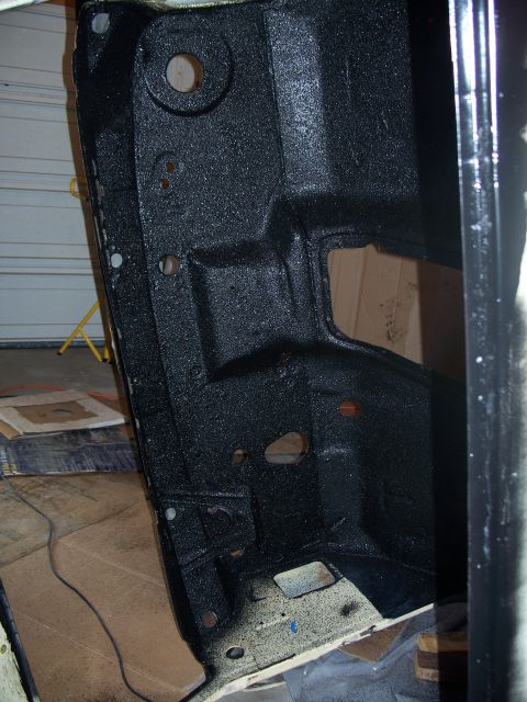 1979 Ford F-150 - A section of a vehicle frame, coated in black, shows mounting holes and structural details.