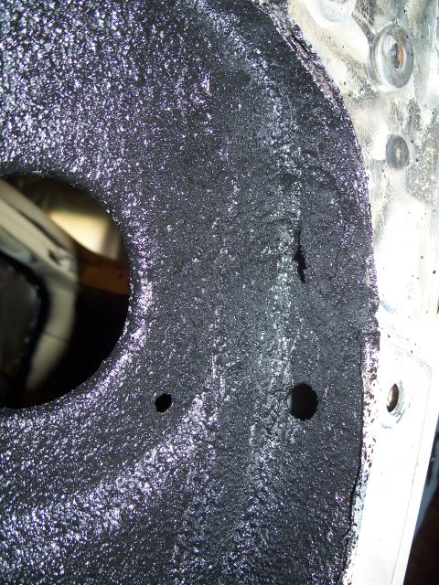 1979 Ford F-150 - Close-up of a textured engine block casting with visible bolt holes and a partial reflection.