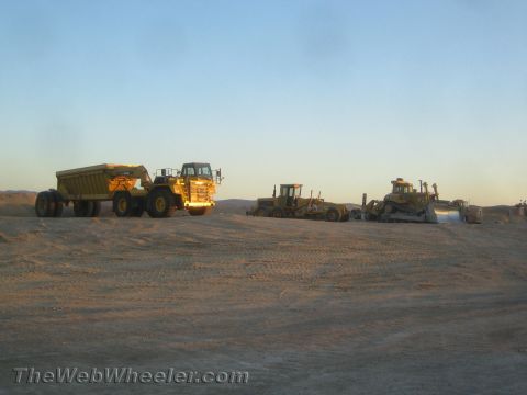 1968 Ford Mustang - Several pieces of heavy construction equipment are parked on a sandy terrain during daylight hours.