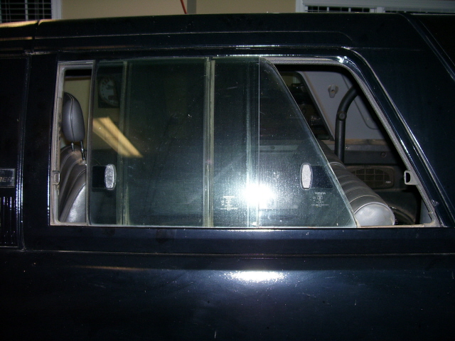 Black SUV side window with sliding vent glass and interior visible