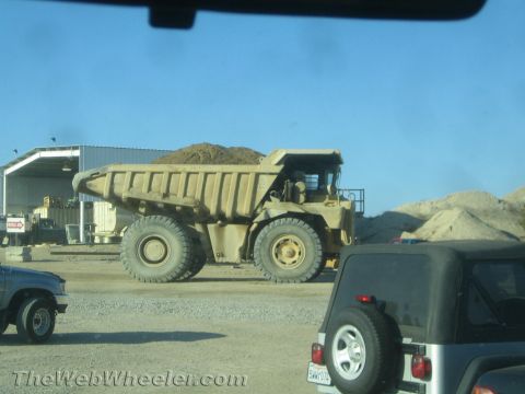 1968 Ford Mustang - A large dump truck is seen at a construction site, with a Jeep partially visible in the foreground.