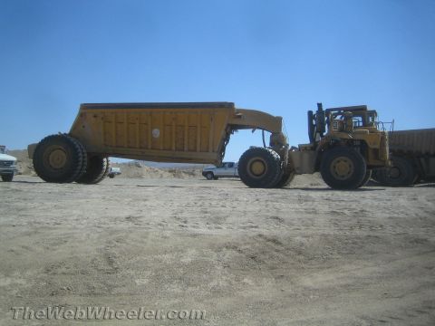 1968 Ford Mustang - An articulated dump truck is parked on a dirt lot, with another vehicle visible in the background.