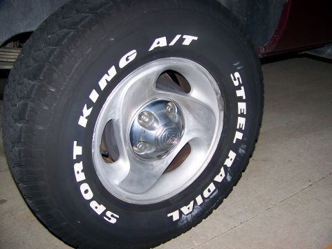 2001 Dodge 1500 - Close-up of a truck wheel and tire with white lettering. The wheel has five lug nuts visible.