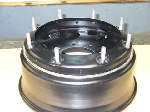 1978 Ford Bronco - A black steel wheel rim with eight lug studs is shown up close against a neutral background.