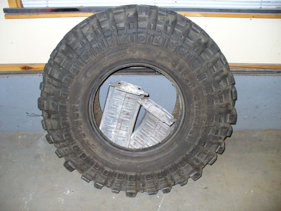 Big off-road tire with two metal parts inside. Supermotors.net logo visible