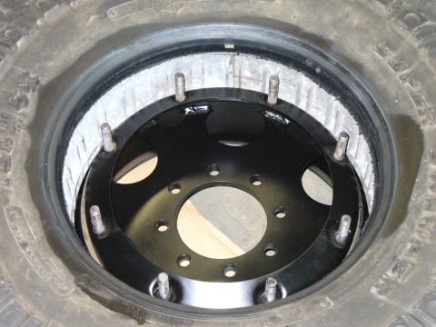 1978 Ford Bronco - Close-up of a spare tire with a wheel adapter installed.
