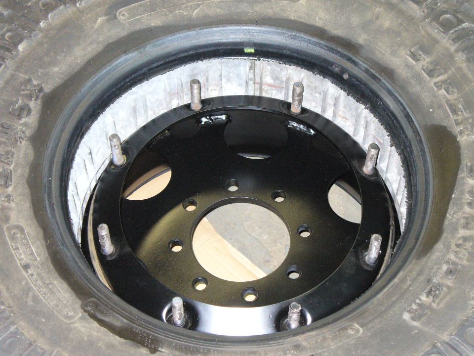 Spare tire showing a black wheel adapter with multiple bolt holes inside the rim