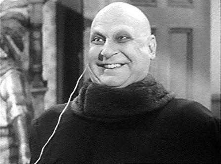 2000 Ford Crown Victoria - A black and white photo shows a bald man with a broad smile, wearing a dark turtleneck and an earphone.