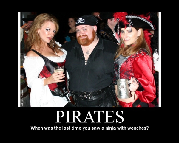 Three people in pirate costumes, two women and one man, posing for a photo. The woman on the left holds a drink, and the woman on the right holds a metal mug