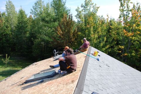 1996 Ford Bronco - Workers are on a roof, preparing for new shingles, with a skylight visible.