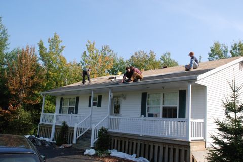 1996 Ford Bronco - Roof repair work in progress on a residential house with several people on the roof.