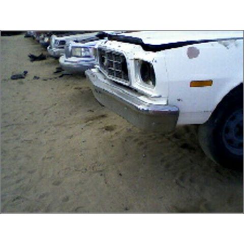 1973 Ford Ranchero - Several vehicles are parked in a dirt lot, showing their front ends and grilles.