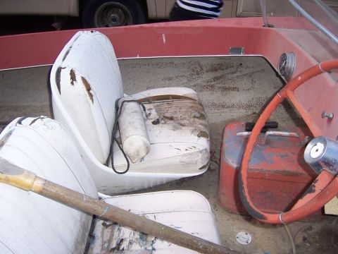 1991 Ford Bronco - Interior of a boat showing damaged seats, steering wheel, and a gas can.