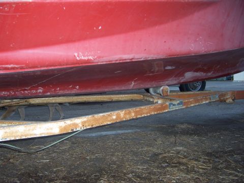 1991 Ford Bronco - Red boat resting on a trailer, with a dog visible underneath.