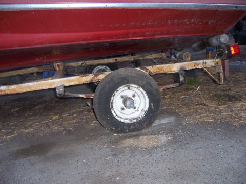 1991 Ford Bronco - Close-up of a red boat resting on a trailer, showing the trailer's wheel and frame.