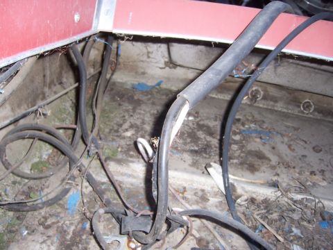1991 Ford Bronco - Close-up of a messy vehicle wiring harness with many black cables and some exposed wires.