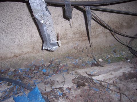 1991 Ford Bronco - The photo shows damaged wiring and conduit against a textured concrete wall, with debris on the ground.