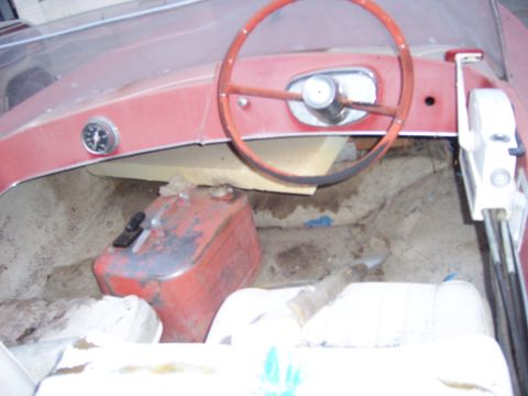 1991 Ford Bronco - Interior view of a red boat with a steering wheel and a red gas can.
