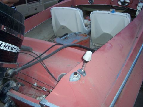 1991 Ford Bronco - Interior view of a red boat, showing white seats and a Mercury outboard motor.