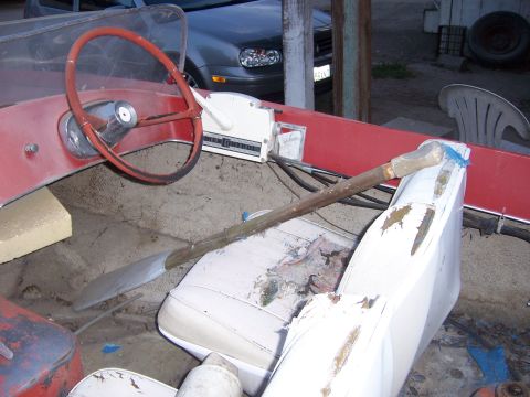 1991 Ford Bronco - Interior view of a boat showing the steering wheel, throttle control, and a shovel resting on the seats.