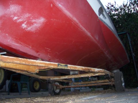 1991 Ford Bronco - The underside of a red boat is visible, resting on a trailer with visible rust.