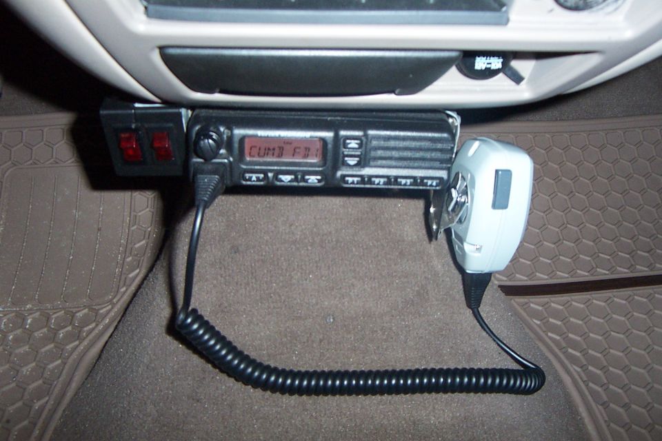 CB radio and microphone mounted under dashboard, with two red switches