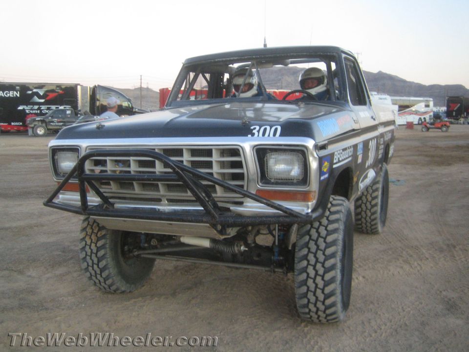 Blue Ford number 300 off-road race truck with two helmeted occupants