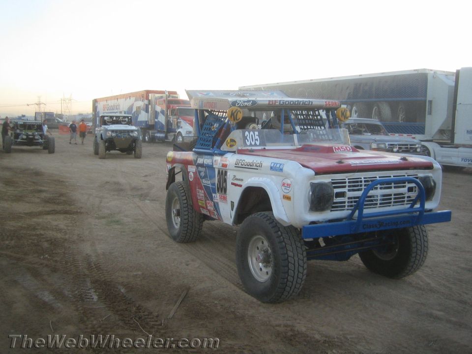 Red white and blue number 305 Bronco race truck on a dirt road